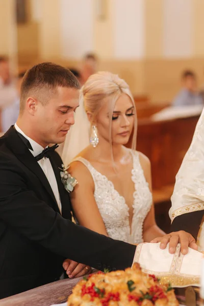 美丽的夫妇在教堂。新婚夫妇发誓要永远相爱。愉快的新娘和新郎 — 图库照片