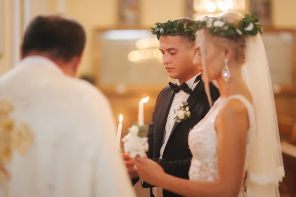 Belo casal na igreja. Os recém-casados juram um ao outro amar para sempre. Noiva feliz e noivo — Fotografia de Stock