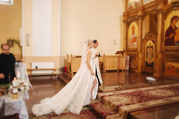 Belo casal na igreja. Os recém-casados juram um ao outro amar para sempre. Noiva feliz e noivo — Fotografia de Stock