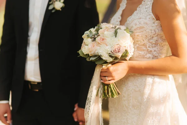 Strauß in den Händen der Bräute. Bräutigam mit seiner Frau. Mittlere Reife — Stockfoto