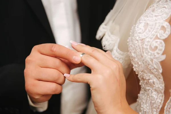 Закрыть руки жениха и невесты с кольцом — стоковое фото