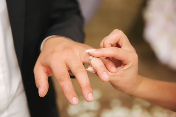 Κοντινό χέρι γαμπρός και νύφη φορώντας ένα δαχτυλίδι — Φωτογραφία Αρχείου