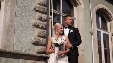 Damat ve gelin Merdivenlerde dur. Şık giysileriyle moda modeli. Beyaz uzun elbise ve şık takım elbise