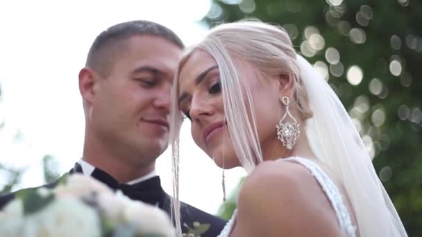 Primer plano del novio y la novia. Hermosa pareja de bodas en el parque. Recién casados con estilo — Vídeo de stock