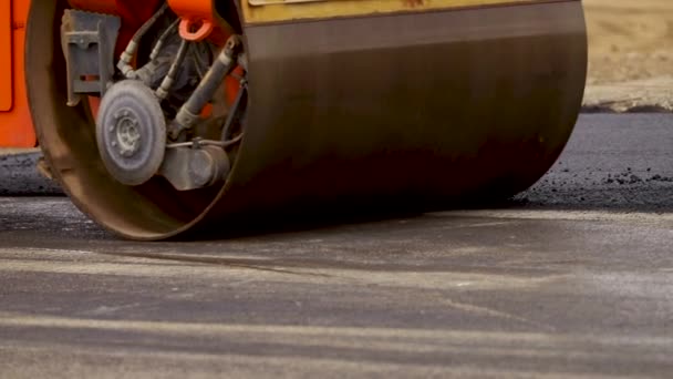 El pavimentador se mueve en una carretera plana de nueva construcción, embistiendo y nivelando. Aserradero de asfalto aplicando asfalto en la carretera de la ciudad reparada — Vídeos de Stock