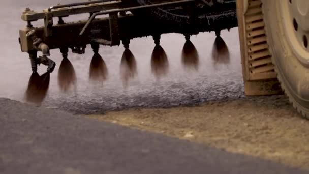 Maschine sprüht Bitumen auf die neue Straße. Asphalt — Stockvideo