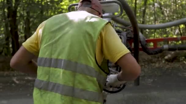 Punktuelle Reparatur von Gruben auf der Straße. neuer Asphalt. Arbeiter setzen große Maschine für Straßenreparaturen ein — Stockvideo
