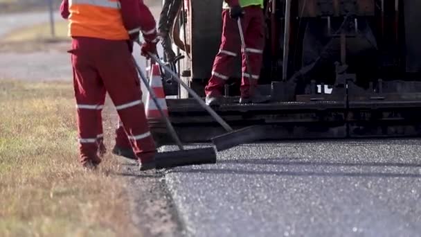 Leveling new rad. Asphalt on the road. Smoothing out the road. Workers are working outside. Bitumen — Stock Video