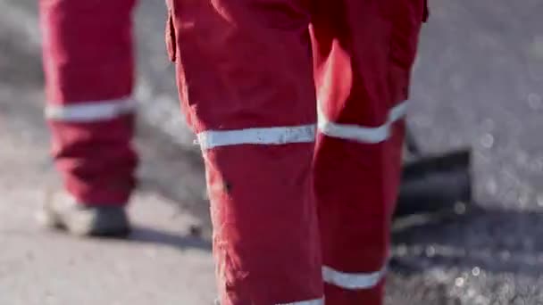 Nivellierung des neuen Rades. Asphalt auf der Straße. die Straße zu glätten. Arbeiter arbeiten draußen. Bitumen — Stockvideo