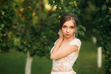 Güzel makyaj ve saç fotoğrafçısına poz ile büyüleyici gelin