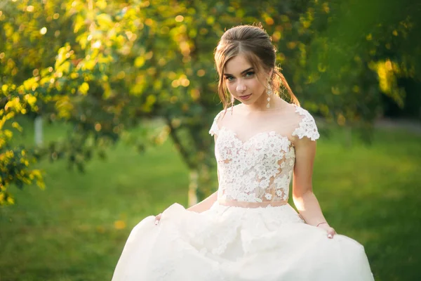 Encantadora novia con hermoso maquillaje y peinado posando para el fotógrafo — Foto de Stock