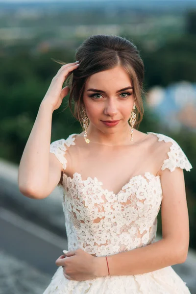 Hermosa novia en vestido de novia largo fuera. Jovencita con hermosos ojos — Foto de Stock