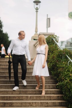 Genç bir çift yürür, merdivenlerden aşağı burada duvarda büyük bir plaj büyür gider