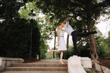 Genç çift parkta yürüyüş. İyi eğlenceler ve sevinirler. Siyah-beyaz elbise