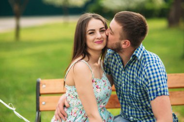 Bir bankta siting çift ve pembe helyum topları tutmak