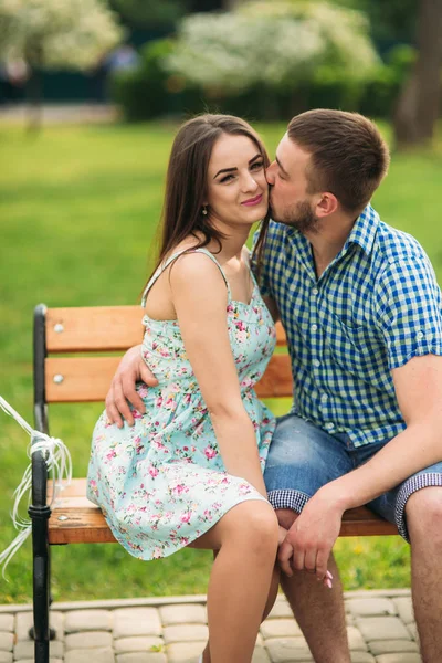 Couple siting on a bench and hold pink helium balls — Stock Photo, Image