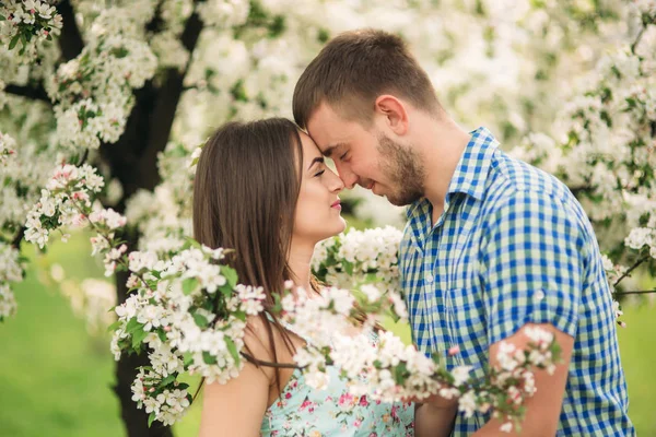 Portrét mladého páru v jarní náladě. Kvetoucí stromy kolem muž a žena — Stock fotografie