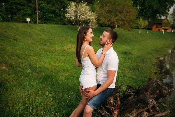 Citas en el parque. Pareja de amor de pie juntos en la hierba cerca del lago. Romance y amor — Foto de Stock