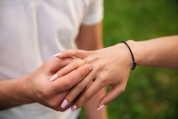 El hombre le hace una propuesta de matrimonio a una chica. Le da un anillo para el compromiso. Primer plano de las manos —  Fotos de Stock