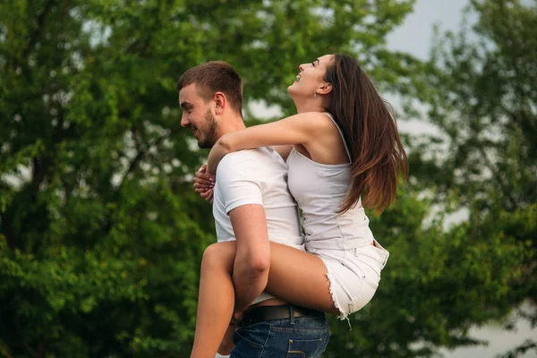 Dos personas se divierten. Chica y niño corren cerca del lago —  Fotos de Stock