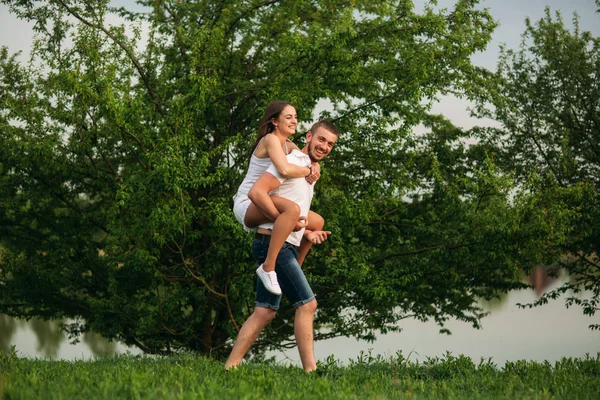 Δύο άνθρωποι να διασκεδάσουν. Κορίτσι και αγόρι, που τρέχει γύρω, κοντά στη λίμνη — Φωτογραφία Αρχείου