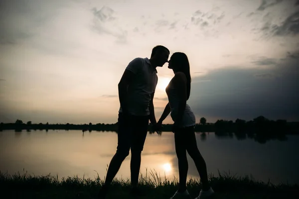 Silhouette de beau couple. lac en arrière-plan — Photo
