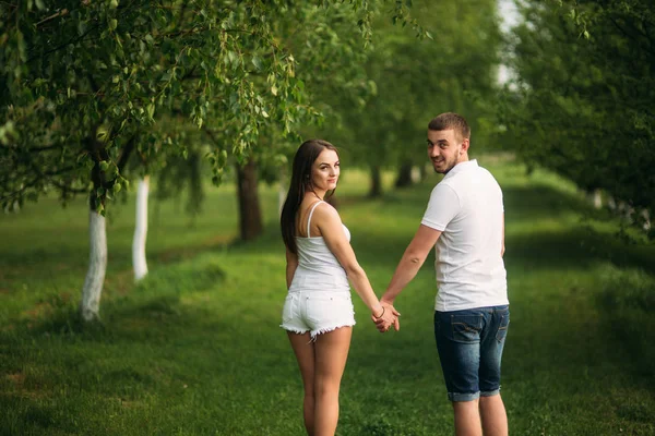 Hombre y mujer caminando por el parque. Hermosa pareja —  Fotos de Stock