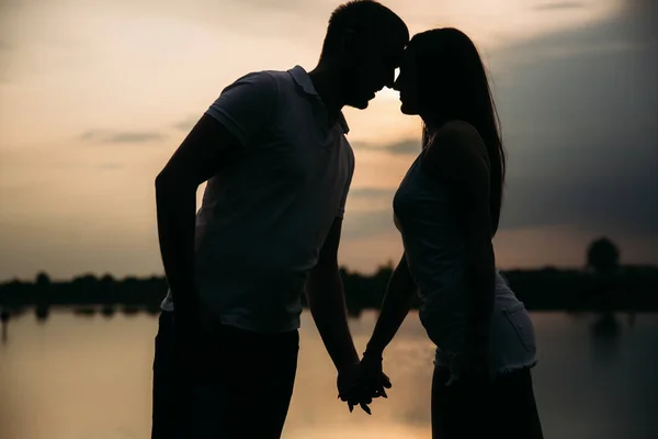 Silueta de hermosa pareja. lago en el fondo —  Fotos de Stock