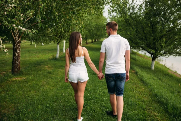 Man en meisje lopen rond het park. Mooi paar — Stockfoto