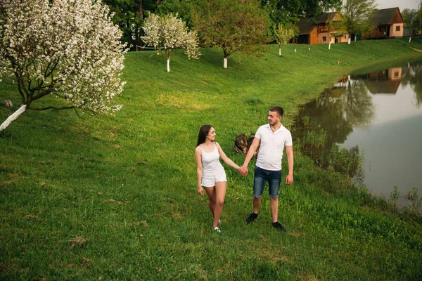 Dating in park. Love couple standing together on grass near the lake. Romance and love