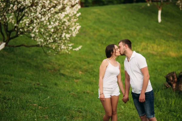 Citas en el parque. Pareja de amor de pie juntos en la hierba cerca del lago. Romance y amor —  Fotos de Stock