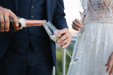 Damat ve gelin şehir ve İçecek şampanya bardağı üzerinden arka plan üzerinde durmak. Kodes gözlük