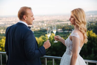 Evlilik çift şehir ve İçecek şampanya bardağı üzerinden arka plan üzerinde durmak. Alkış