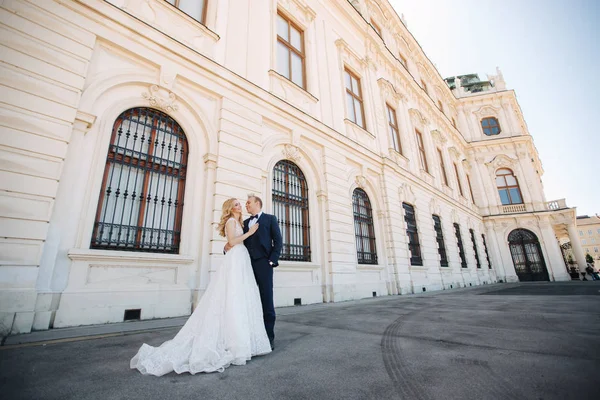 Çift büyük palace yanında yürümek. Zarif damat ve gelin düğün giysileri içinde. Aşk — Stok fotoğraf