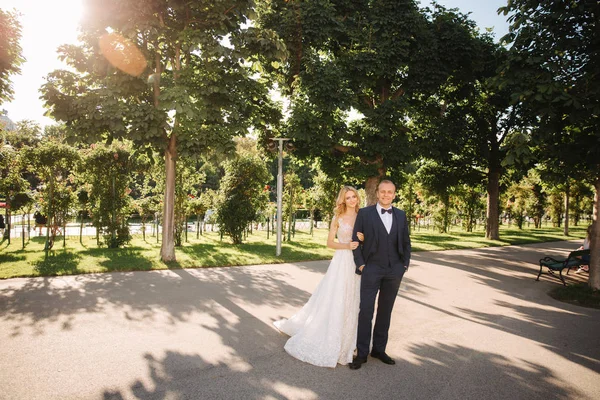 愉快的年轻夫妇在他们的婚礼日花时间在公园。绿色背景 — 图库照片