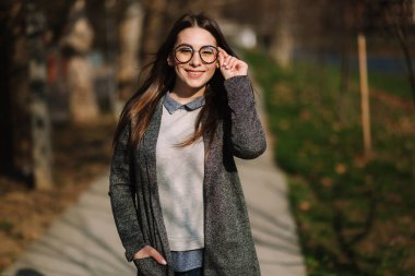 Gri ceket ve gömlek güzel kız moda güneş gözlüğü giymek. Genç kız gülümseme