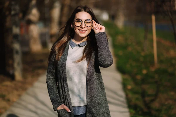 Menina bonita em jaqueta cinza e camisa usar óculos de sol de moda. Menina jovem sorriso — Fotografia de Stock