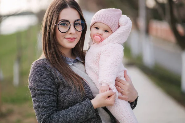 Anne ve onun küçük kız portresi. Güzel anne ve sevimli bebek. Anne kızı HUD. Bebek fıstık ch renkli şapka ve meme oyuncak giyinmiş