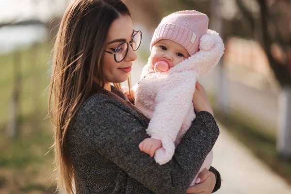 Anne ve onun küçük kız portresi. Güzel anne ve sevimli bebek. Anne kızı HUD. Bebek fıstık ch renkli şapka ve meme oyuncak giyinmiş — Stok fotoğraf