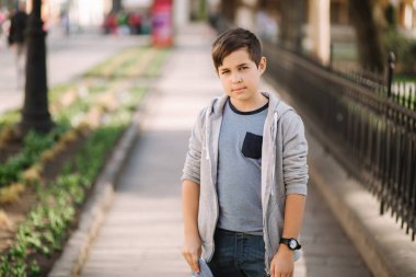 Şehirde yürürken sevimli bir çocuk. Dışında şık genç çocuk