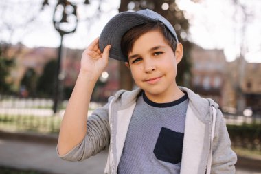 Mavi kapak şık küçük okul çocuk fotoğraf için dışarıda poz. Çocuk yaz hava sping şehirde yürüyüş