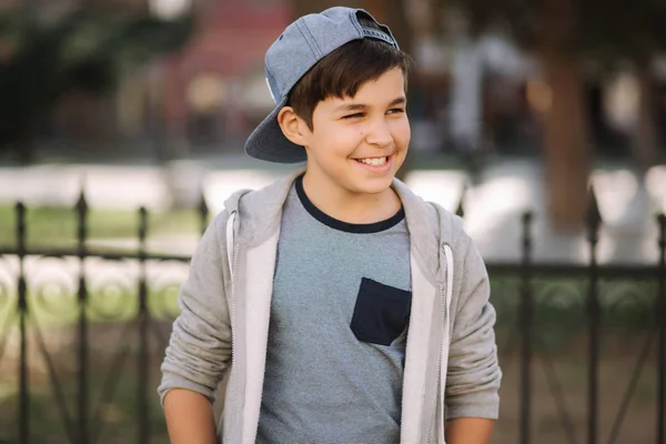 Schöner Junge mit Mütze spaziert durch die Stadt — Stockfoto