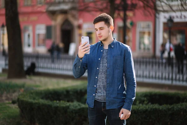 Joven hombre dispara vídeo en smartphome en el centro de la ciudad — Foto de Stock
