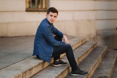 Park yakınındaki merdivenlerden üzerinde sitiing yakışıklı adam