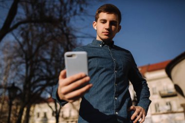 Adam bir telefon kullanarak buttom görünümü. Genç Blogger folowers için bir mesaj Texing