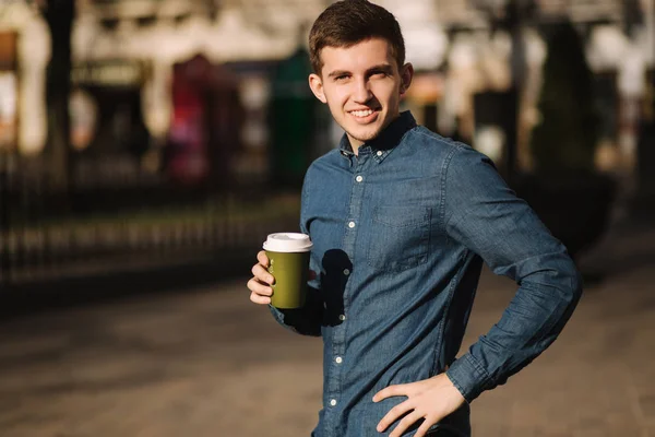 El joven bebe café afuera. Puesta de sol de primavera — Foto de Stock