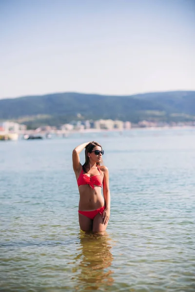 Hermosa chica en un traje de baño rosa, en el mar. Señora sexy — Foto de Stock