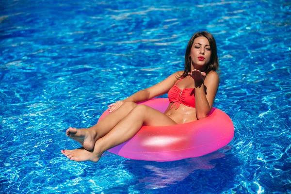 Jovem corpo de mulher bonita moda na piscina. Menina bonita segurando um anel de borracha — Fotografia de Stock