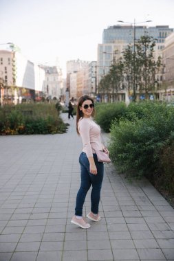 Mavi elbiseli güzel bir kız parkta yürüyor. Güneşli bir gün. Yaz