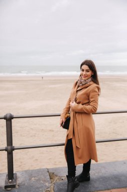 Kuzey Denizi boyunca güzel ceket ayakta makyaj ile şık bayan. Kadın gülümseme